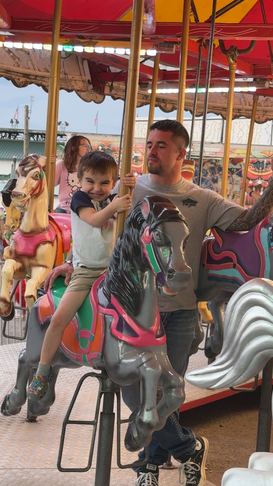 Johnny beside Elliot on a carousel