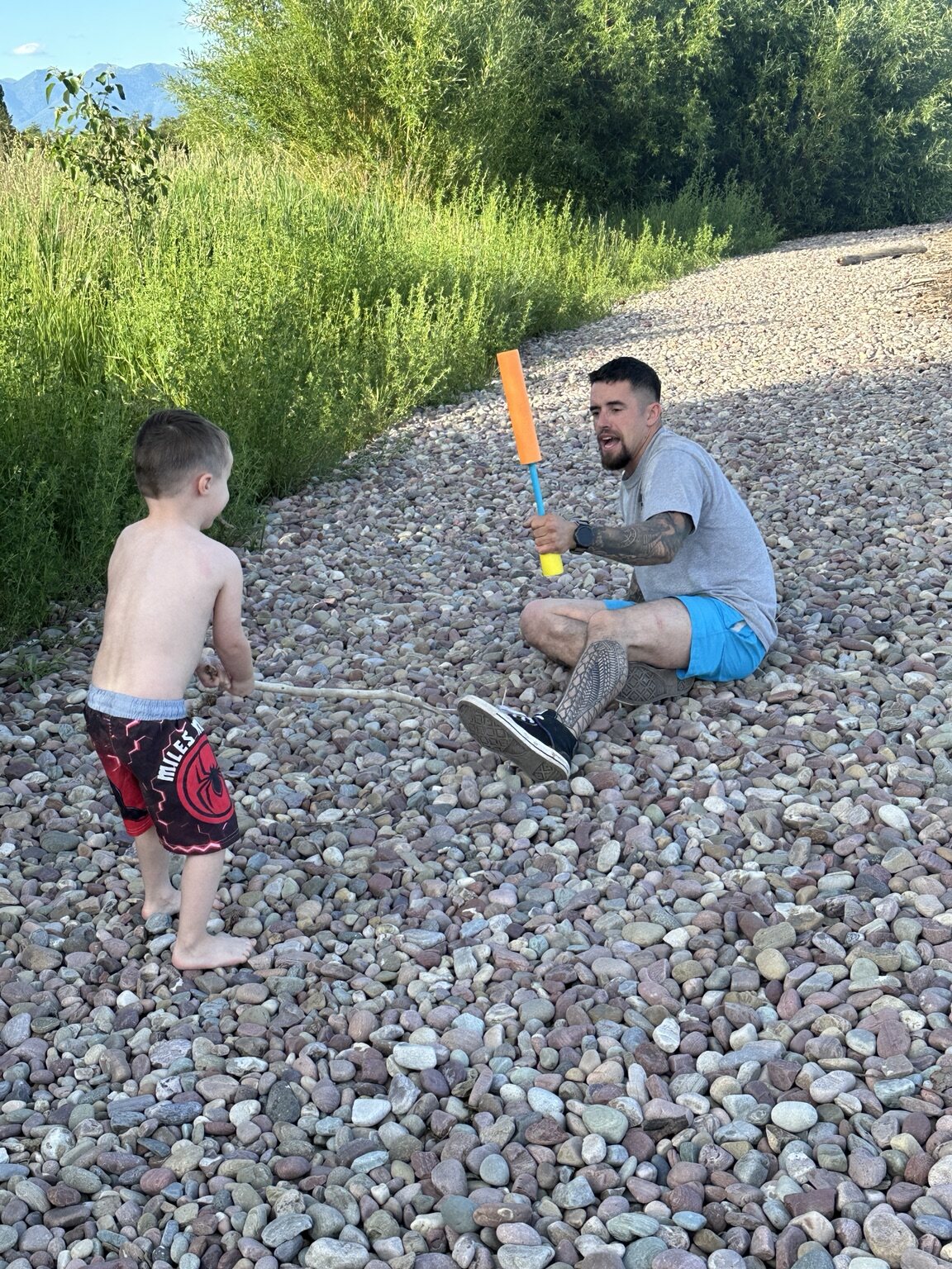 Johnny and Elliot playing together by the river